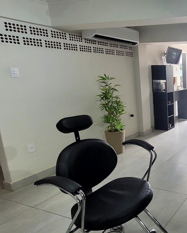 Cadeira de atendimento do estúdio, com planta e ar-condicionado ao fundo